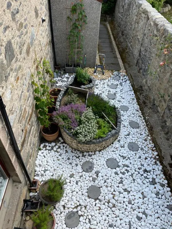 a garden with flowers and plants on a path at Garden Park Guest House in Grantown on Spey