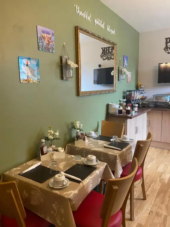 a dining room with two tables and a mirror at No 29 Bed and Breakfast in Inverness
