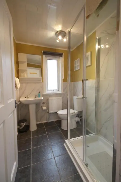 a bathroom with a shower and a toilet and a sink at Arrandale in Inverness