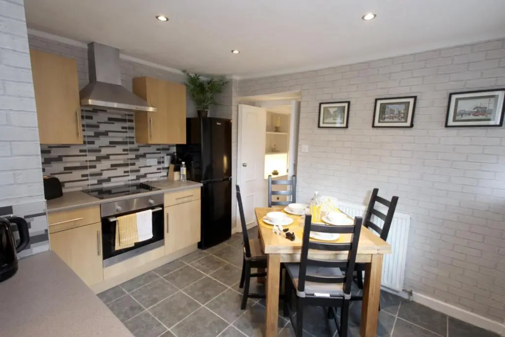 a kitchen with a wooden table with chairs and a stove at Arrandale in Inverness