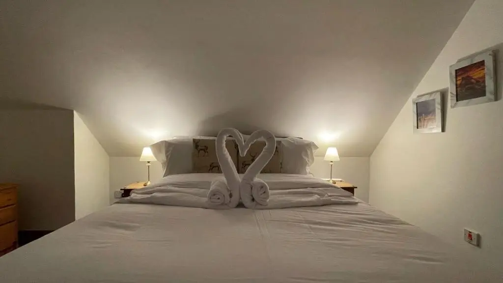 a white bed with a heart made out of towels at Kerrowdown Cottage-Self Catering for 4 in the Highlands in Drumnadrochit