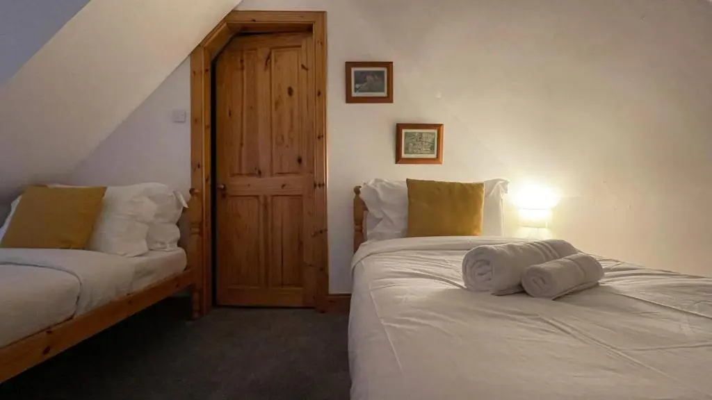 a bedroom with two beds with towels on them at Kerrowdown Cottage-Self Catering for 4 in the Highlands in Drumnadrochit