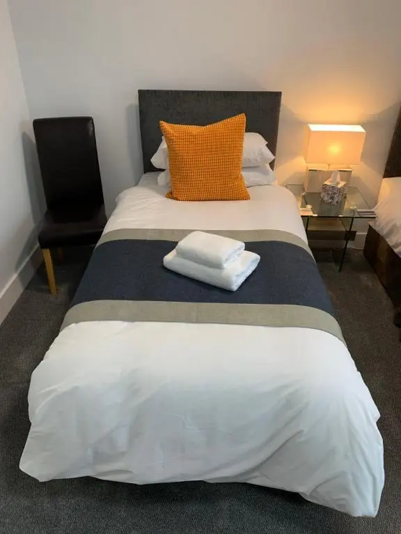 a bedroom with a bed with two towels on it at Muir Bank in Muir of Ord