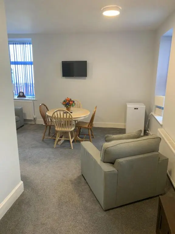 a living room with a couch and a table at Muir Bank in Muir of Ord