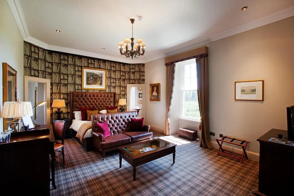 a living room with a couch and a table at Meldrum House Hotel Golf And Country Estate in Oldmeldrum