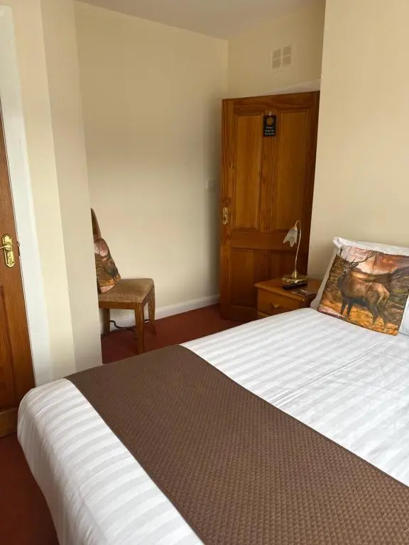 a bedroom with a bed and a chair in it at Wimberley House in Inverness