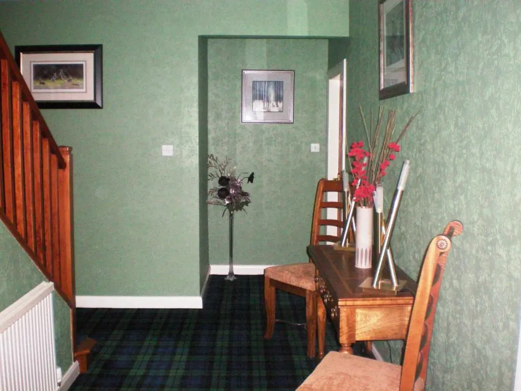 a dining room with a table and a table and chairs at Wimberley House in Inverness