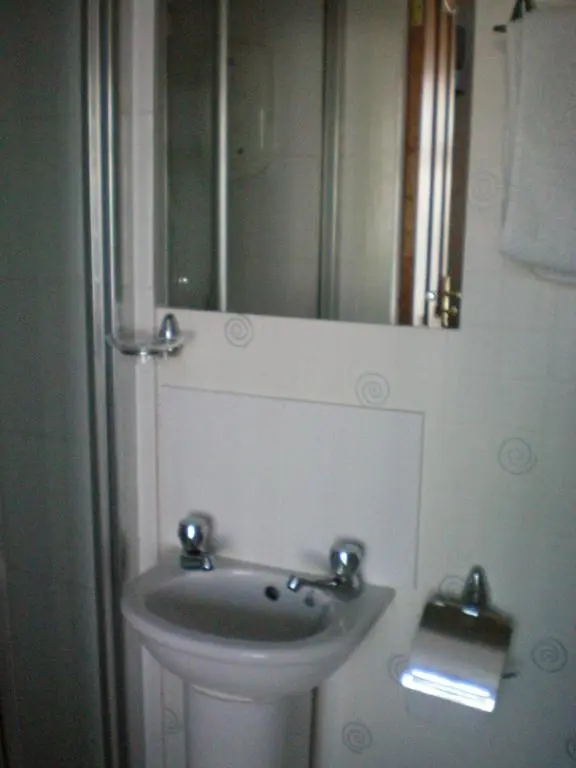 a bathroom with a sink and a mirror at Wimberley House in Inverness