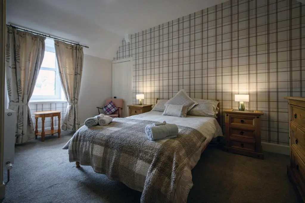a bedroom with a bed with a tiled wall at Charming Townhouse on North Coast 500 Route, Wick in Wick
