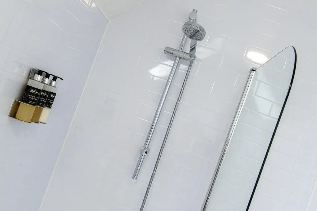 a shower in a bathroom with white tiles at Charming Townhouse on North Coast 500 Route, Wick in Wick