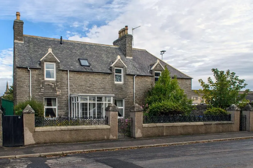 a large brick house on the side of a street at Charming Townhouse on North Coast 500 Route, Wick in Wick