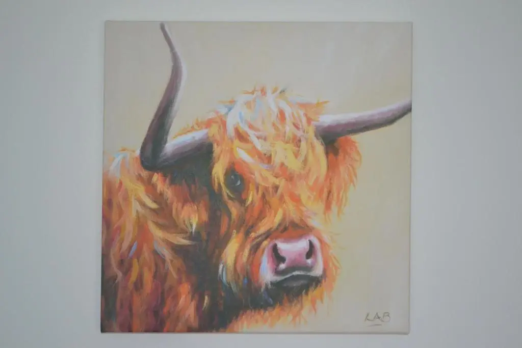 a painting of a cow with horns on a wall at Kirkside Holiday Home in Alness
