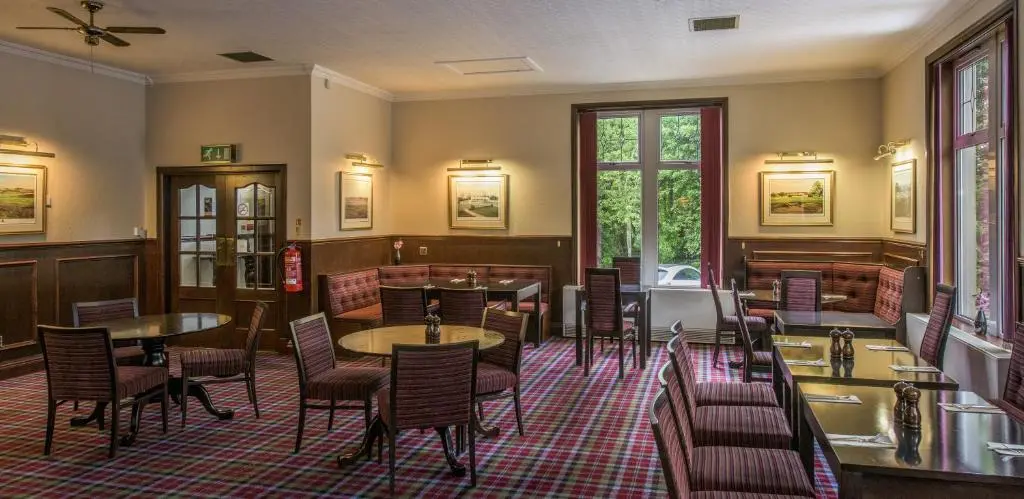 a restaurant with tables and chairs in a room at Pinehurst Lodge Hotel -Dyce, Aberdeen in Dyce