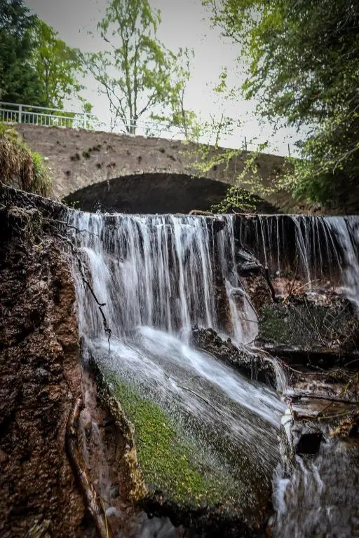 a waterfall on the side of a hill at A UNIQUE Experience in a Converted Shipping Containers, Glamness is Adults Only in Inverness