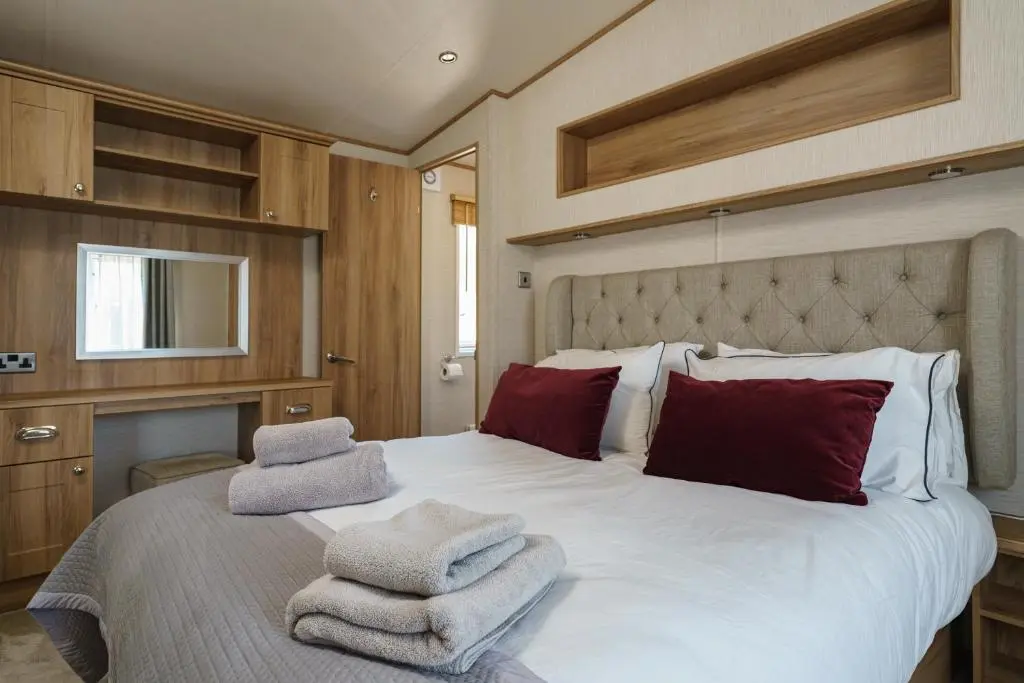 a bedroom with a large bed with towels on it at Ruapehu Lodge in Aviemore