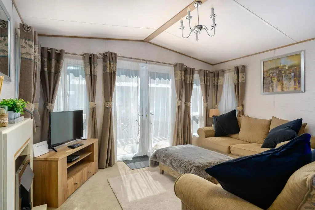 a living room with a couch and a tv at Ruapehu Lodge in Aviemore