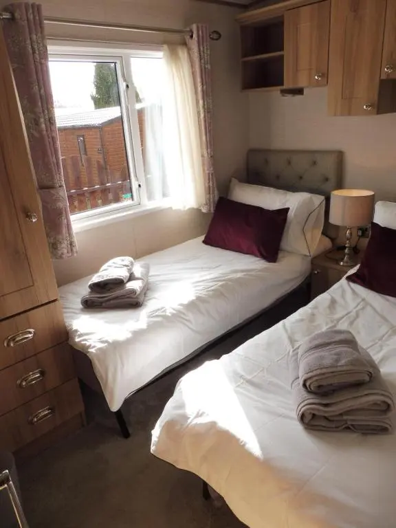 two beds in a small room with a window at Ruapehu Lodge in Aviemore