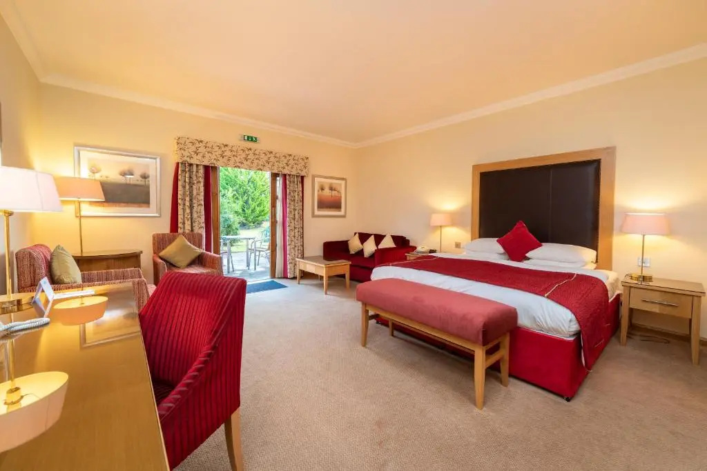 a large hotel room with a bed and a couch at Inverness Lochardil House, by Highland Coast Hotels in Inverness