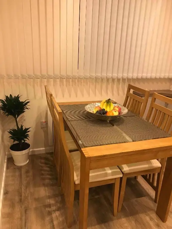 a wooden table with a bowl of fruit on it at exploreNESS Apartment in Inverness