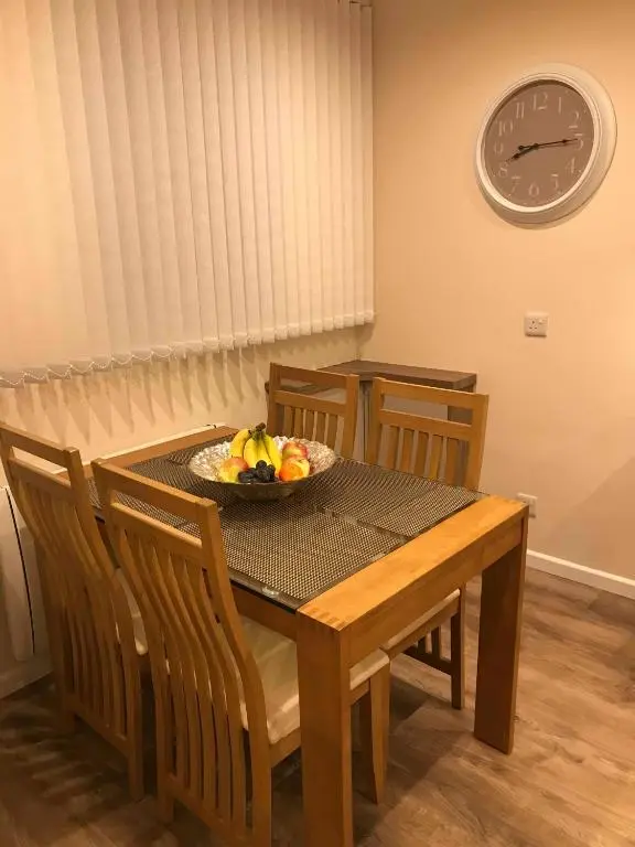 a dining room table with a bowl of fruit on it at exploreNESS Apartment in Inverness
