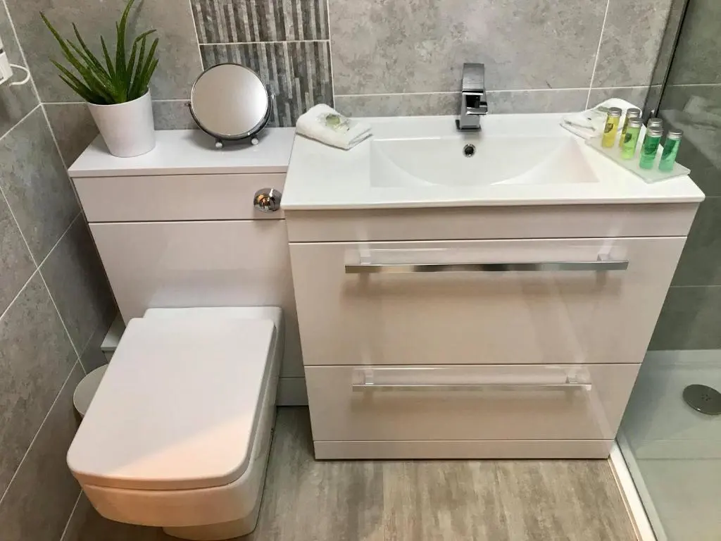 a bathroom with a white sink and a toilet at exploreNESS Apartment in Inverness