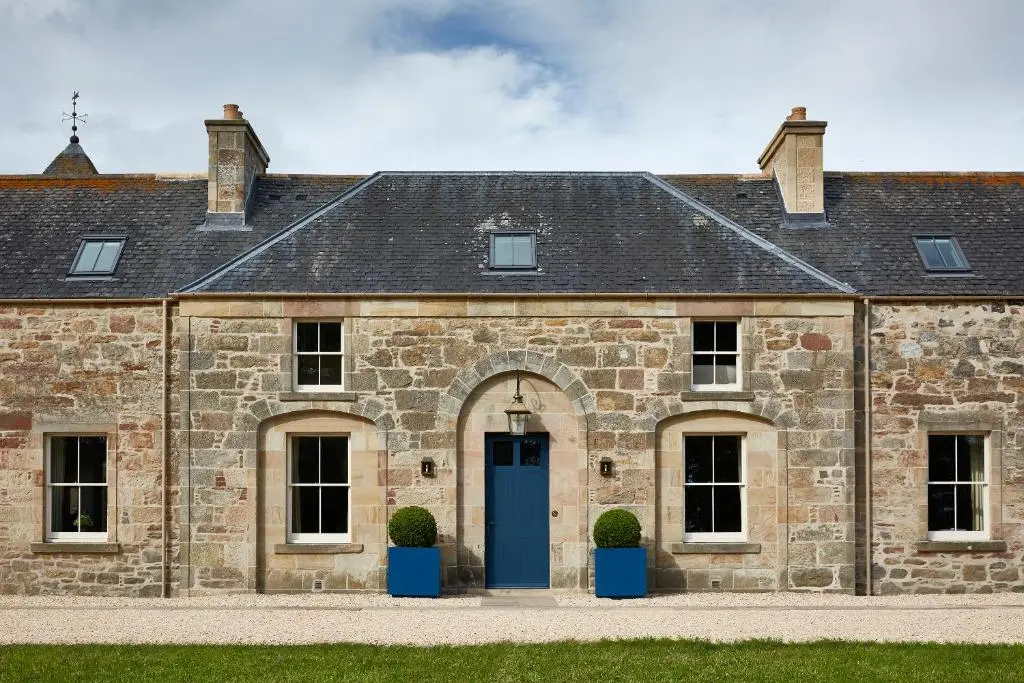 an old stone building with a blue door at Newhall Mains in Resolis