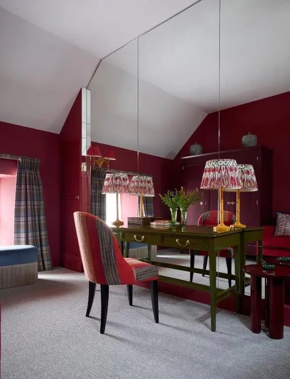 a living room with a table and a red wall at Newhall Mains in Resolis