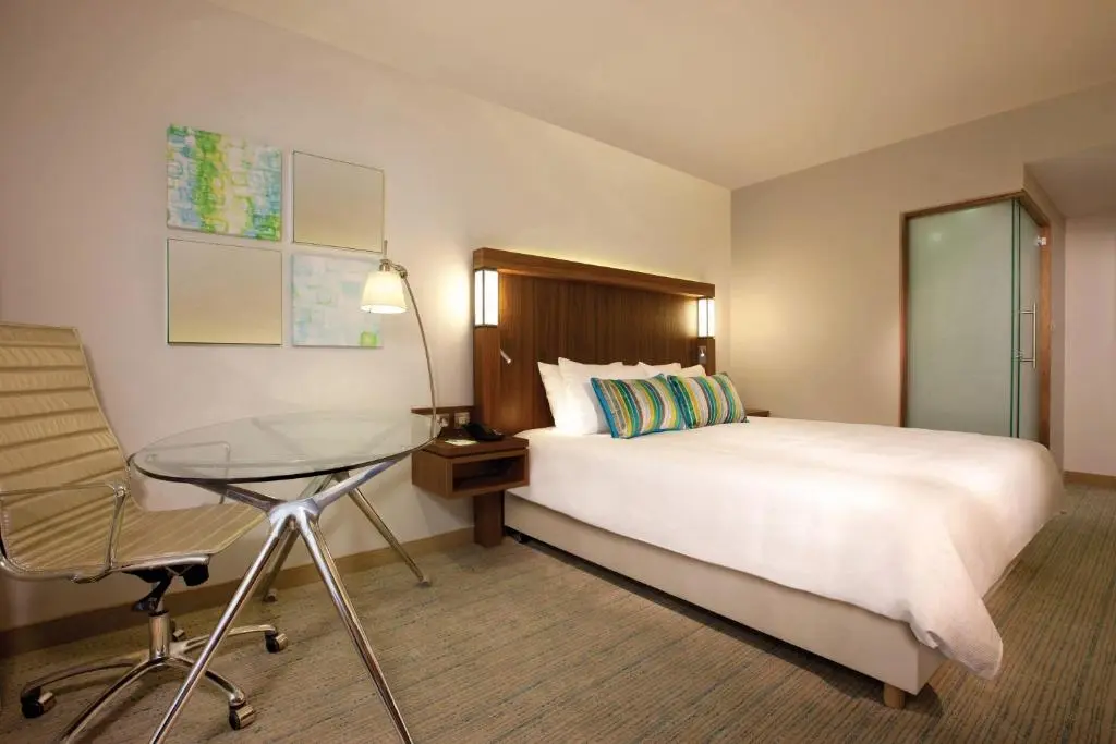 a hotel room with a bed and a glass table at Courtyard by Marriott Aberdeen Airport in Dyce