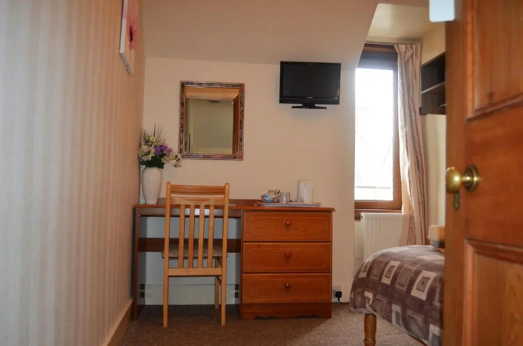 a bedroom with a desk with a chair and a mirror at The Quaich B&B in Inverness