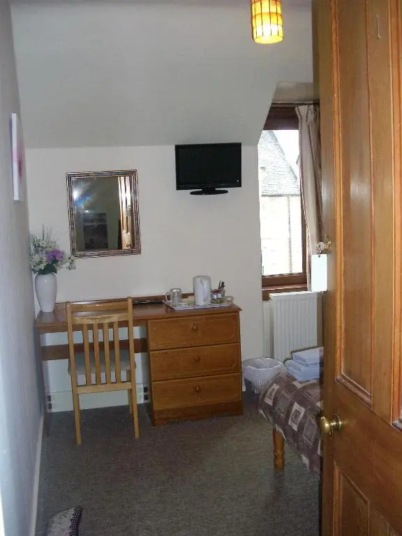 a room with a desk with a television and a chair at The Quaich B&B in Inverness