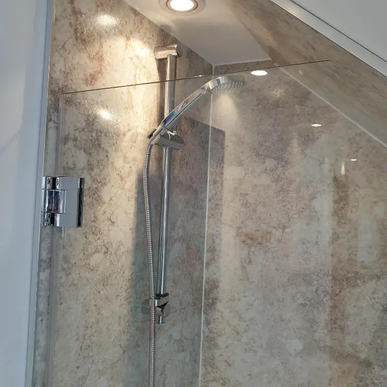 a shower with a glass door in a bathroom at Aldo's Place in Dingwall
