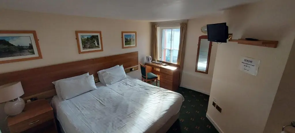a hotel room with a bed and a television at Gordon Arms Hotel in Fochabers