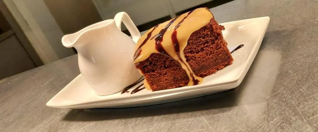 a piece of chocolate cake on a plate on a table at Gordon Arms Hotel in Fochabers