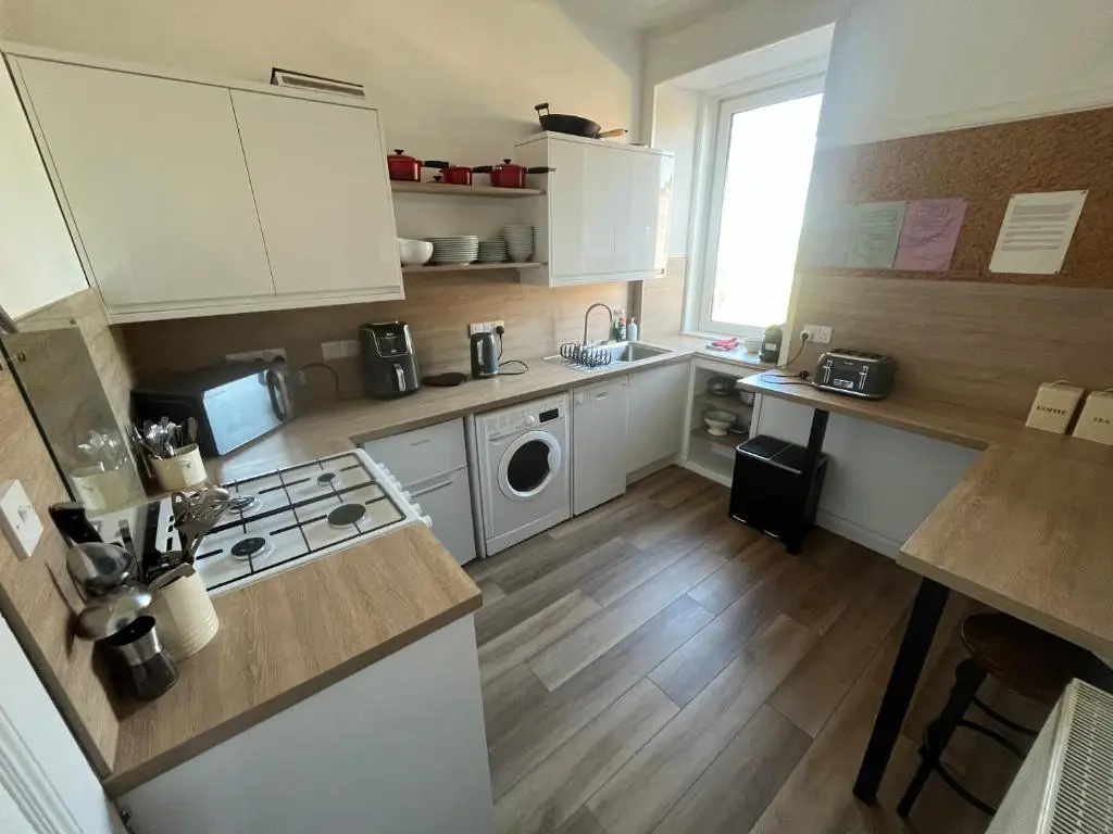 a kitchen with white cabinets and a stove top oven at Period House / Entire Upstairs Flat in Inverness