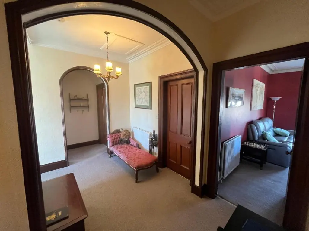 a living room with a chair and a couch and a mirror at Period House / Entire Upstairs Flat in Inverness
