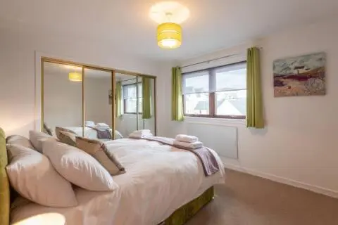 a bedroom with a large bed and a window at Number 5, Muirfield Court in Inverness