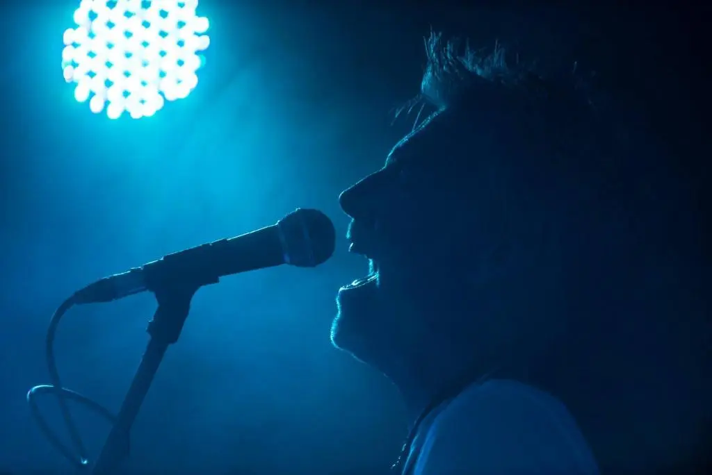 a silhouette of a man singing into a microphone at The Bandstand in Nairn
