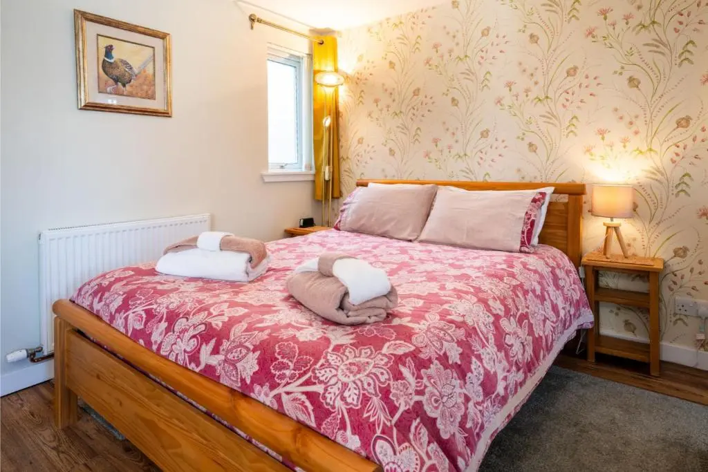 a bedroom with a bed with two towels on it at Courtyard Bothy in Grantown on Spey