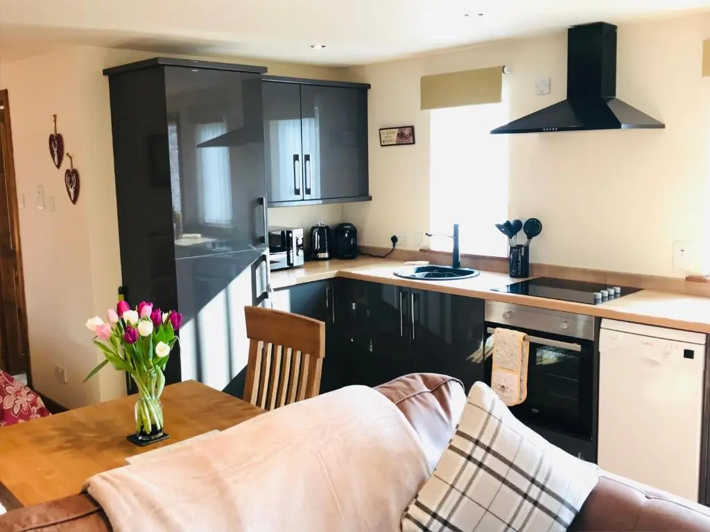 a kitchen with a table with a vase of flowers at Courtyard Bothy in Grantown on Spey