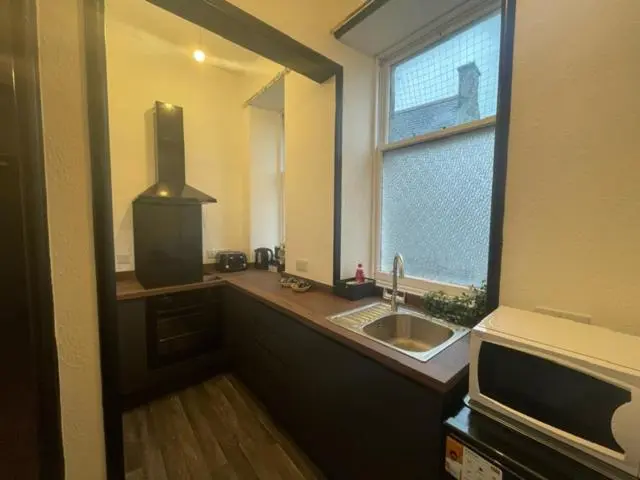 a kitchen with a sink and a window and a microwave at Carlton Hotel in Forres