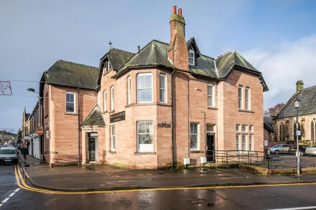 an old brick building on a city street at CASTLEBANK HOUSE FLATS, DINGWALL in Dingwall