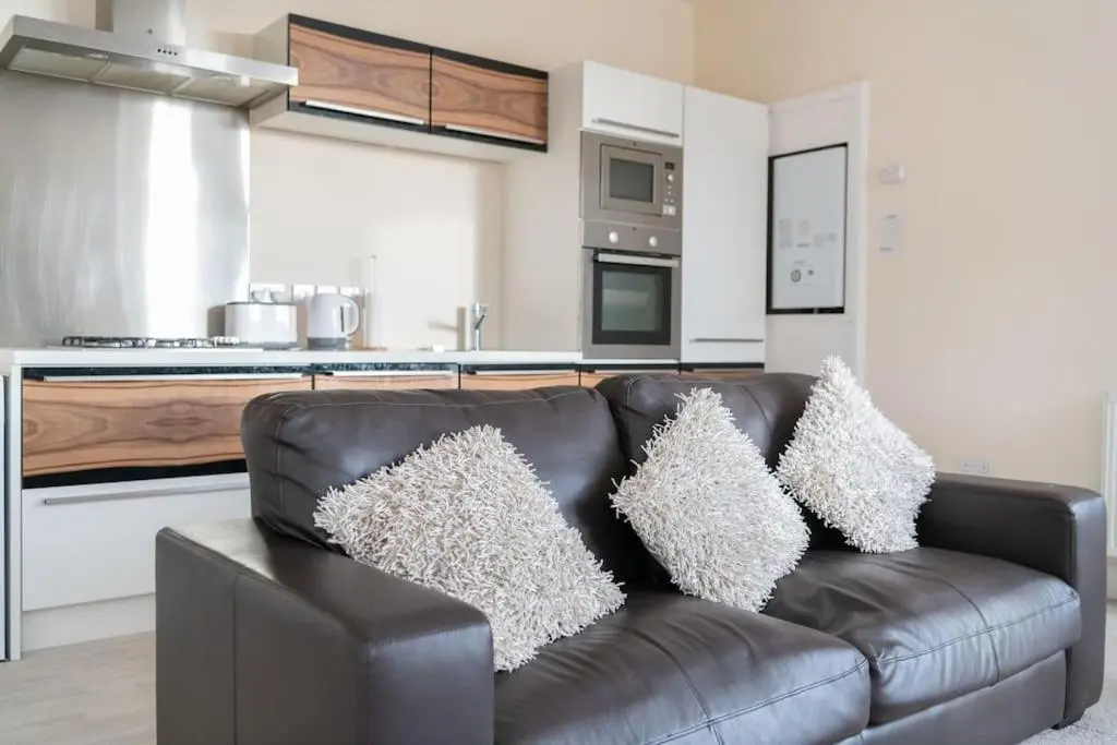 a leather couch with pillows on it in a kitchen at CASTLEBANK HOUSE FLATS, DINGWALL in Dingwall