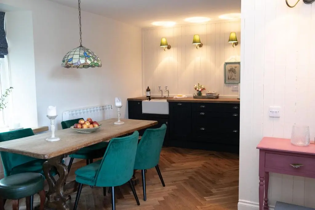 a kitchen and dining room with a table and chairs at Dandaleith Cottage No.1 in Craigellachie