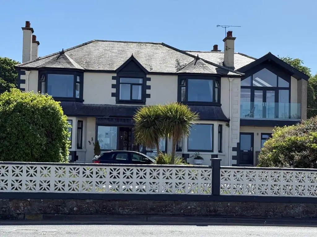 a house with a white fence in front of it at "Stunning Sea-Views" at Wetherby Nairn in Nairn