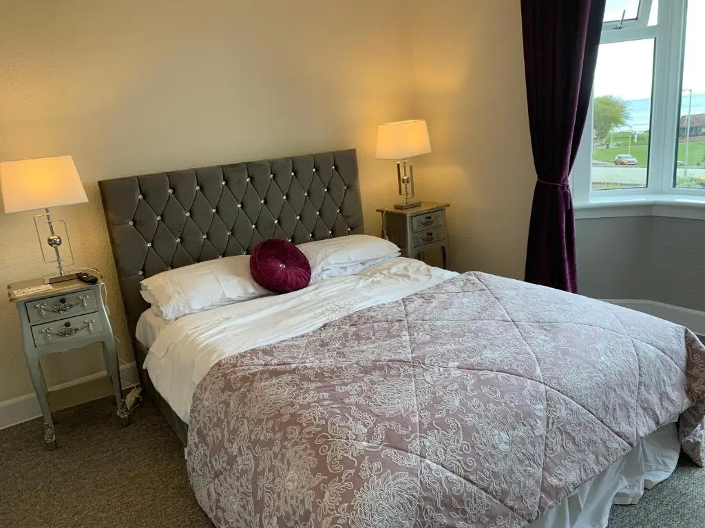 a bedroom with a bed with a red pillow on it at "Stunning Sea-Views" at Wetherby Nairn in Nairn