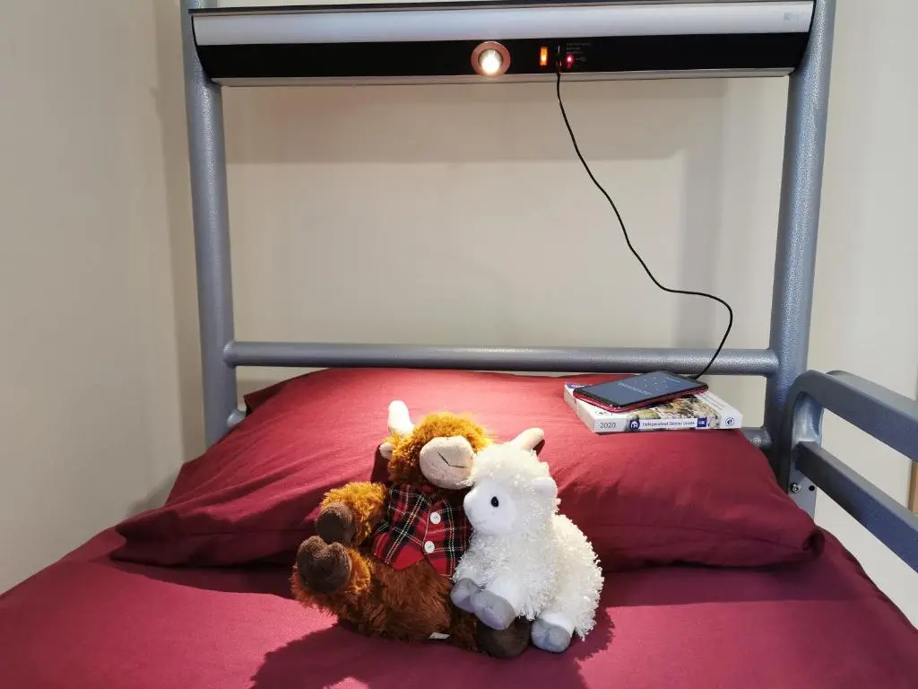 a couple of stuffed animals sitting on a bed at Morag's Lodge in Fort Augustus