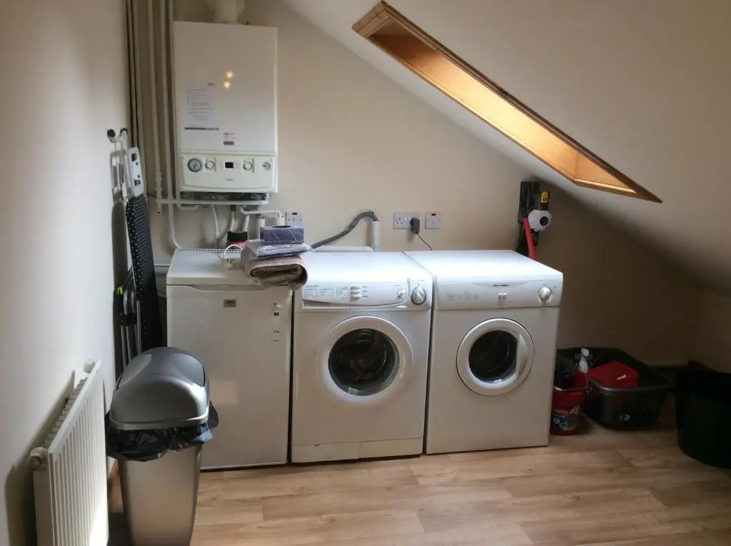 a laundry room with a washer and a washing machine at BORD DE L\u2019EAU APARTMENT in Wick
