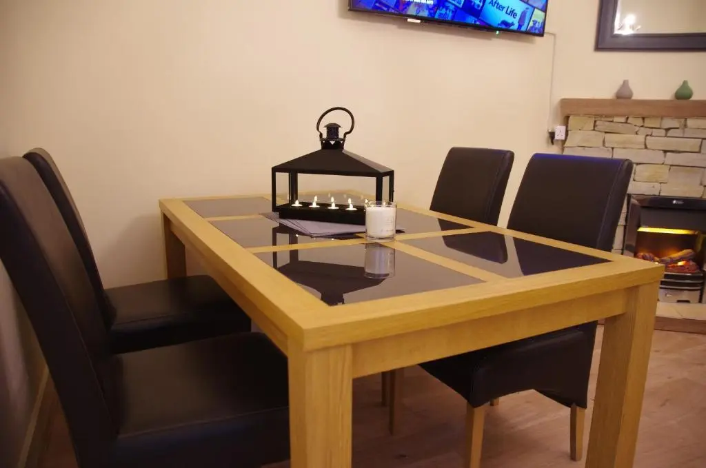a dining room table with chairs and a lamp on it at STAG City Centre apartment in Inverness