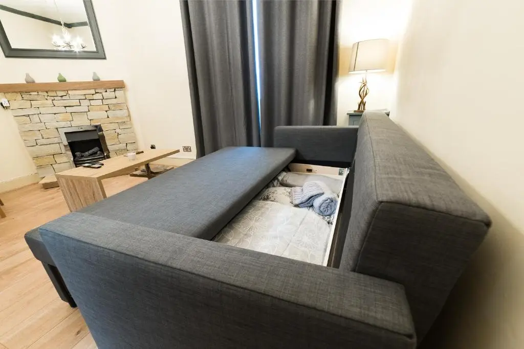 a couch in a living room with a fireplace at STAG City Centre apartment in Inverness