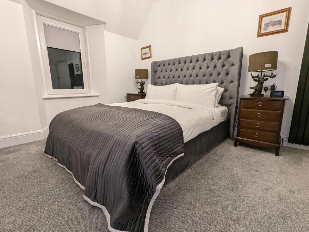 a bedroom with a large bed and a window at Cambeth Lodge Guesthouse in Inverness